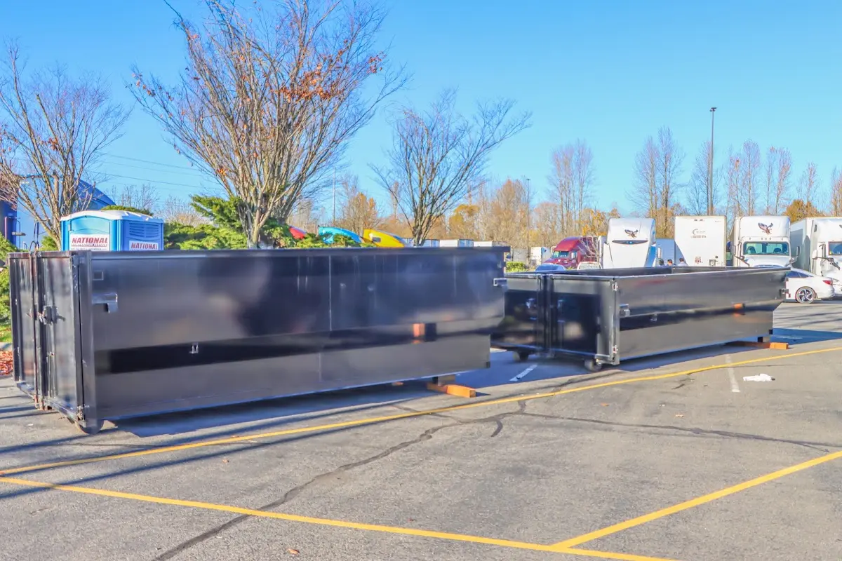 Professional dumpster rental service with roll-off container on residential driveway in Houlton